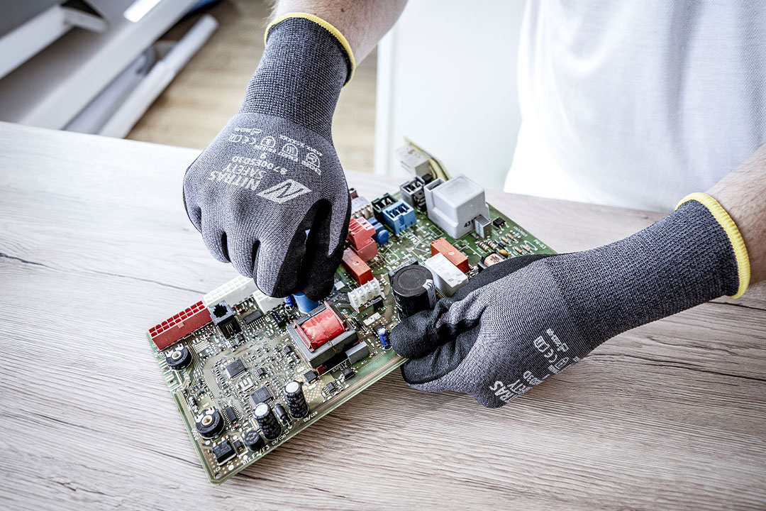Mitarbeiter bei der Arbeit mit Platinen trägt den NITRAS 3D FIT Anistatikhandschuh